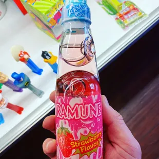 a hand holding a strawberry flavored drink