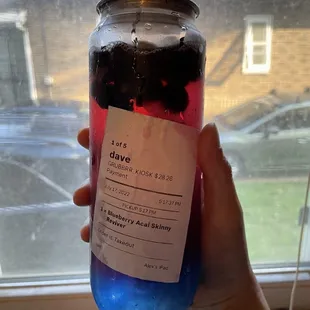 a hand holding a jar of jelly