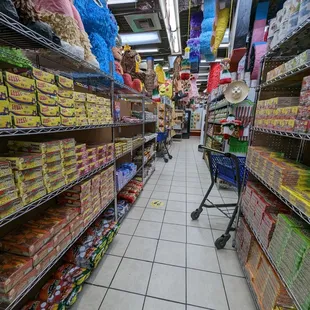 a grocery store aisle with a cart full of candy