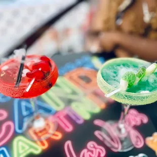two colorful cocktails on a table
