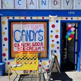 a yellow chair in front of a candy shop