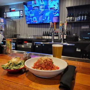 a bowl of pasta and a glass of beer
