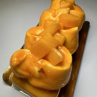 Raspberry cakes covered in white chocolate with smooth whipped berry filler cream topping cover with mango and hints of passion