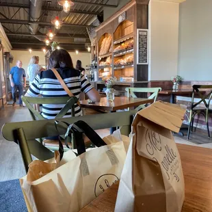 Bread wall and small comfortable table seating inside (they have outdoor seating as well)