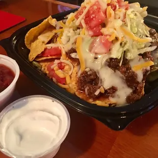 a plate of nachos and a bowl of salsa