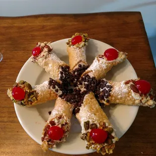 a plate of cannoli on a wooden table