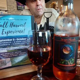 a man sitting at a table with a bottle of wine