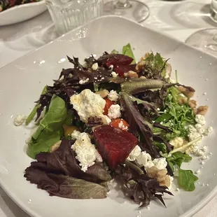 From the 2023 holiday musical show menu: Course 2 -- mixed greens salad topped with fresh beets, goat cheese, walnuts, and Biquinho peppers