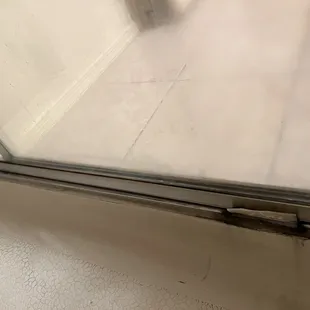 Moldy shower door track that is broken to boot.