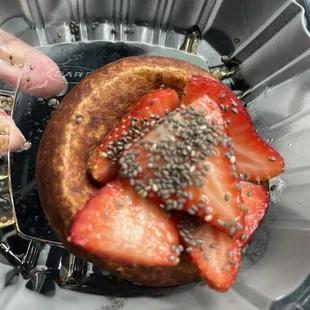 Fresh made donut with strawberries, chia seeds and syrup