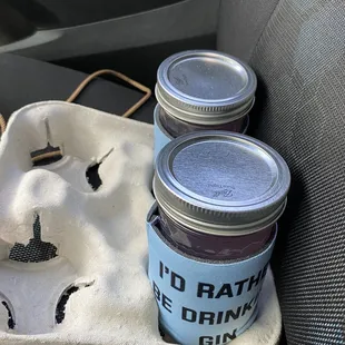 two jars of drink on the seat of a car