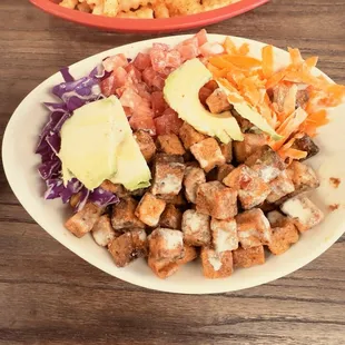 Spicy tofu quinoa bowl with a side of fresh fries
