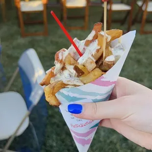 a person holding a cone of french fries