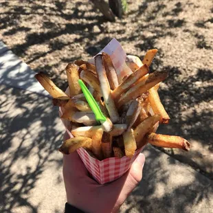 a person holding a basket of french fries