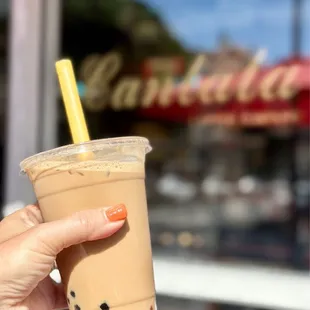 a hand holding a cup of iced coffee