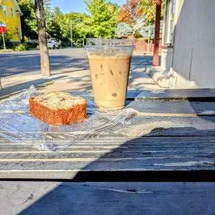 a sandwich and iced coffee on a picnic table
