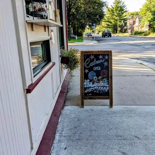 a sidewalk with a sign for a restaurant