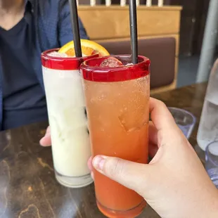 a person holding a drink with two straws