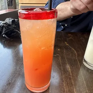 a man sitting at a table with a drink in front of him