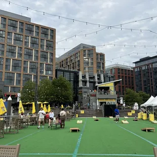 Outdoor seating with cornhole games and big screen TVs