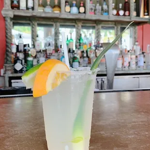 a glass of lemonade with a straw and a slice of orange