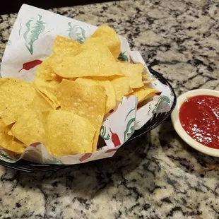 a bowl of tortilla chips and a bowl of ketchup