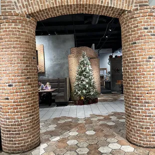 a brick archway with a christmas tree
