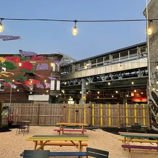 Outdoor seating area at dusk, under the Somerset El station.