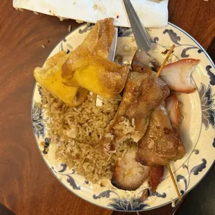 A plate of overcooked food with a rice taste hard like leftovers refried. The chicken was too dry.