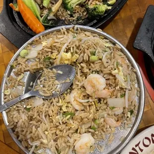 a plate of fried rice with shrimp and vegetables