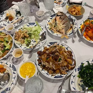 Table Spread - Beef chow fun, fried pompano, sweet and sour pork, chow mein, salt and pepper squid, egg drop soup.