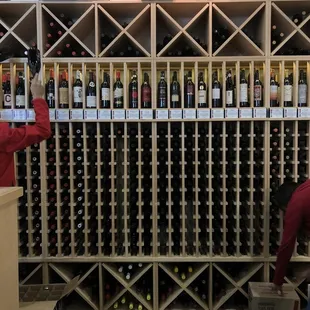 a man looking at bottles of wine