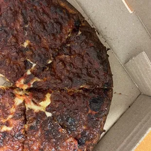 a burnt pizza in a box
