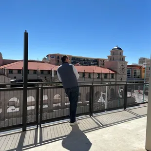 a man standing on a balcony overlooking a city