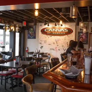the interior of a restaurant with people sitting at tables