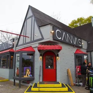the front of a restaurant with a red door
