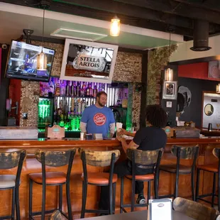a man and woman sitting at a bar