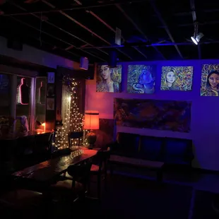 a dimly lit room with paintings on the wall