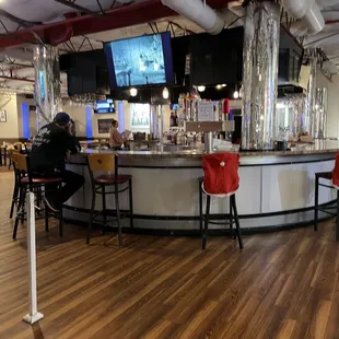 a bar with red chairs