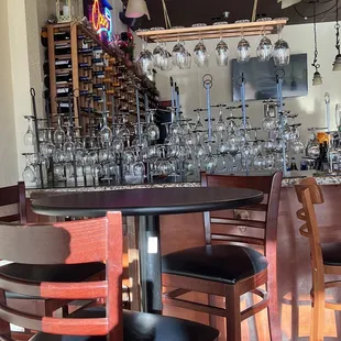 a bar with wine glasses hanging from the ceiling