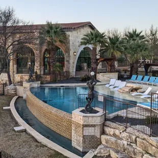an outdoor pool with lounge chairs