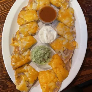 a plate of quesadillas and dips