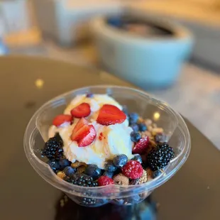 Delicious yogurt bowl with honey, granola and fresh berries