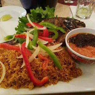 Baked tilapia w/jollof rice &amp; pepper sauce.