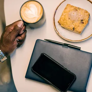 a person holding a cup of coffee and a tablet