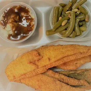 a tray of fried fish, green beans, and mashed potatoes