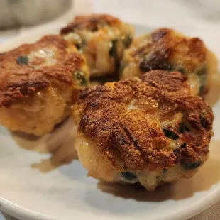 three crab cakes on a white plate