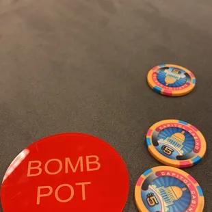 a red bomb pot and four casino tokens