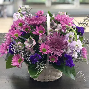 An all purple bouquet arranged in a white basket