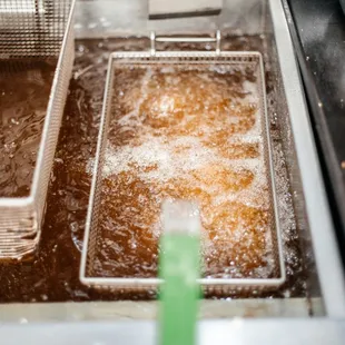 a deep fryer filled with fried donuts